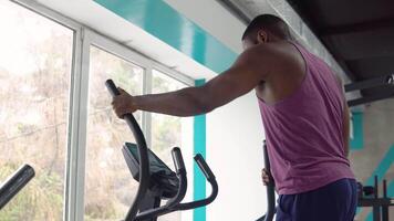 nero uomo allenarsi su cross-trainer nel il palestra. bodybuilding concetto video