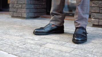 Close-up of a elegant black businessman in black classy shoes and coat near office center video