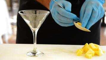 Professional chef hands throwing dice mango fruit in cocktail glass video