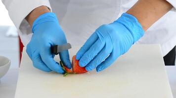 cocinero corte un fresa con un cuchillo en el cocina video