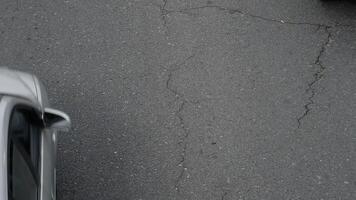 Cars passing in road with asphalt with cracks seen from above video