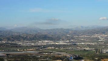 Mountains, city, highway with traffic and airplane passing at sunset video