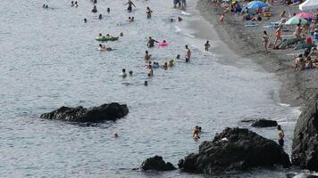 Mediterranean beach with crowd of people bathing in summer video