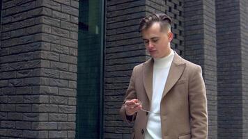 Stylish young man in brown coat with pocket watch on the street video