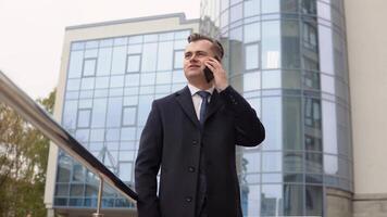 Jeune élégant homme d'affaire parlant sur téléphone près le Bureau centre video