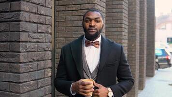 giovane elegante africano americano maschio uomo d'affari nel nero cappotto vicino ufficio centro video