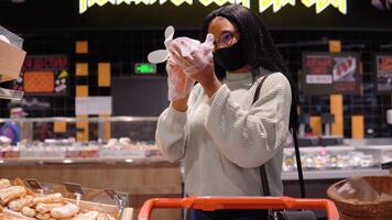 meisje in een masker heeft boodschappen doen in de supermarkt video
