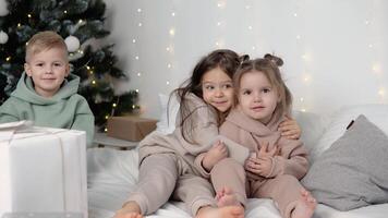 Children hugging near Christmas tree video