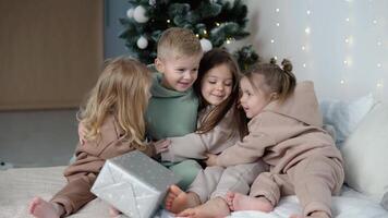 Four children hugging near Christmas tree video