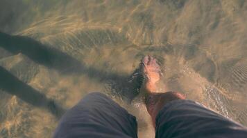 un' camminare su il acqua di un' chiaro lago. maschio gambe nel acqua. video