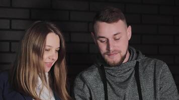 couple avec tablette, une homme et femme partager une fermer, personnel moment tandis que à la recherche à une tablette filtrer, illuminé par le chaud lueur de intérieur éclairage. video