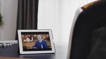 Happy woman talking with her father on a video call using tablet computer.