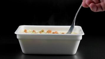 caucasian hand with fork taking cooked instant noodles from styrofoam container video