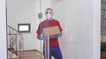 Courier with protection mask delivering package to customer. video