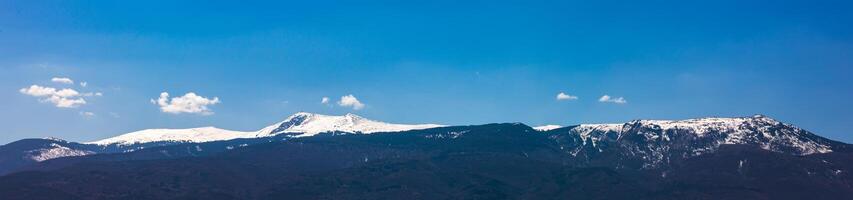 Amazing panorama with snow-capped mountains and hills photo