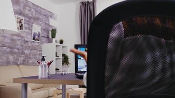 ung kvinna under en video ring upp använder sig av bärbar dator från Hem kontor.