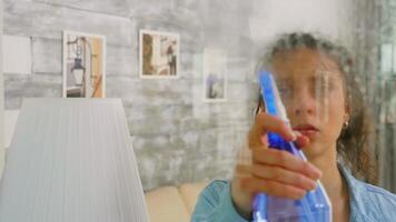 schleppend Bewegung Schuss von Frau Reinigung das Fenster mit sprühen video