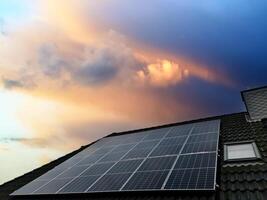 Solar panels producing clean energy on a roof of a residential house photo