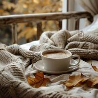 AI generated autumn leaves, cup of coffee and knitted scarf on bed photo