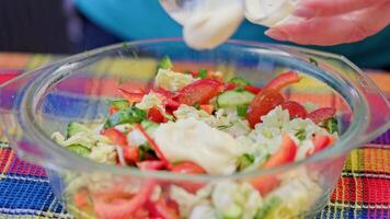 caucásico mujer añadir salsa en cuenco con vegetal ensalada y mezcla eso con cuchara video