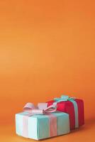 Colorful gift boxes with ribbons on orange background. Copy space for your text, Holiday concept. photo