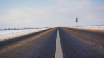 invierno antecedentes de el primer plano de el la carretera con blanco marcas asfalto en invierno. foto