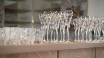 Row of empty wine glasses on bar counter. Beautiful wine glasses on the bar table. Crystal clear empty wine glasses on the table. Alcohol background. A lot of wine glasses at the bar. photo