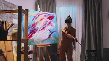 Futuristic painter in studio wearing virtual reality headset. video