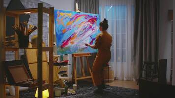 Painter using fingers on large canvas making a masterpiece in art studio. video