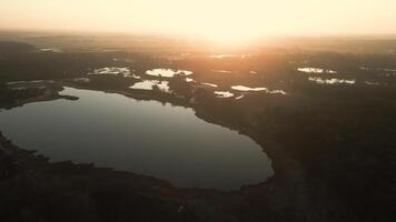 le coucher du soleil brille vers le bas sur Lac dans vert rural paysage video