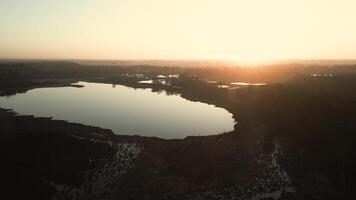 Sunset shines down on lake in green rural landscape video