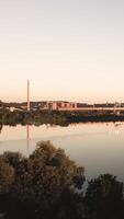 aerial view over the lake to buildings in sunsets video