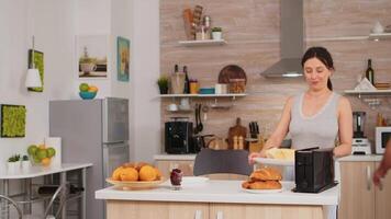 Frau mit Toaster zu braten Brot im Küche während Frühstück. jung Hausfrau beim Zuhause Kochen Morgen Mahlzeit, heiter mit Zuneigung und Liebe video