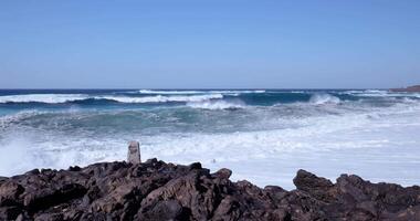 un Oceano ola choque el rocas en el apuntalar video