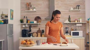 Woman spreading butter on toasted bread for breakfast. Knife smearing soft butter on slice of bread. Healthy lifestyle, making morning delicious meal in cozy kitchen. Traditional tasty lunch video