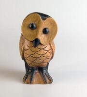 Brown wooden owl figurine carved from hardwood on a white background. photo