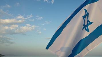 agitant Israël drapeau sur le coucher du soleil océan video