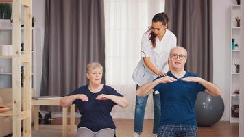 enfermeira ajudando Senior casal com seus fisica treinamento. casa assistência, fisioterapia, saudável estilo de vida para velho pessoa, Treinamento e saudável estilo de vida video