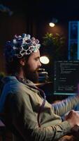 Vertikale Video Computer Ingenieur mit eeg Headset, beginnend Verstand hochladen Prozess mit Gehirn Maschine Schnittstelle. Mann mit neurowissenschaftlich Gerät zu Transfer Bewusstsein in Cyberspace, Tippen Code, Kamera b