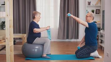 anziano coppia esercizio utilizzando yoga stuoia e stabilità sfera. vecchio persona salutare stile di vita esercizio a casa, allenarsi e addestramento, sport attività a casa video