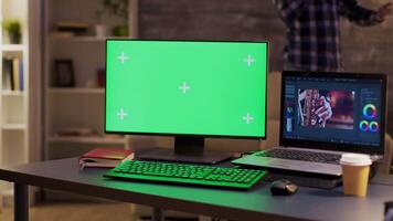 ordinateur moniteur avec vert écran de une vidéaste. contenu créateur parlant sur le téléphone dans le Contexte. Zoom dans tir. video