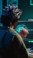 Vertikale Video Mann mit eeg Headset auf Schreiben Code zulassen ihm zu Transfer Verstand in Computer virtuell Welt, Werden einer mit ai. transhumanistisch mit neurowissenschaftlich Technologie zu transzendieren, Kamera ein