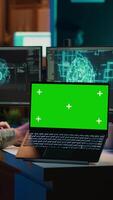 Vertikale Video Ingenieur mit eeg Headset auf Programmierung Gehirn Transfer in Computer virtuell Welt Nächster zu Grün Bildschirm Laptop. transhumanistisch mit Neurowissenschaften zu dazugewinnen Digital Seele, Attrappe, Lehrmodell, Simulation Gerät, Kamera ein