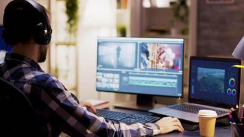 Content creator wearing headphones and taking a sip of coffee while working on a multimedia project using modern software. video