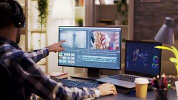 Filmmaker wearing headphones and taking a sip of coffee while working on post production for a movie. video