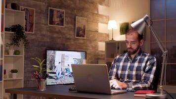 Focused businessman while working on laptop from home office during night hours. video