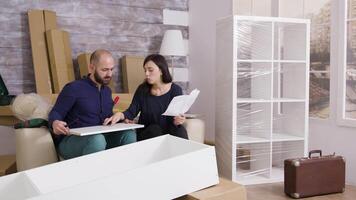 par leende medan montering en hylla som en team och läsning instruktioner. video