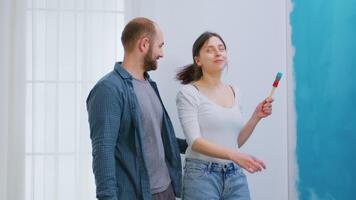 alegre casado casal tendo Diversão durante casa renovação. apartamento redecoração e casa construção enquanto renovando e melhorando. reparar e decoração. video