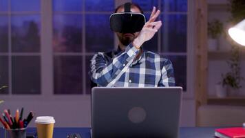 jovem homem de negocios usando virtual realidade óculos enquanto trabalhando dentro casa escritório durante às noite. video