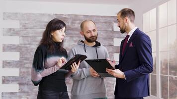 real inmuebles agente en negocio traje hablando acerca de finanzas con clientela a comprar nuevo departamento. corredor con clientela en vacío departamento. video